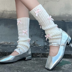 Jambières en maille côtelée beige avec nœuds en satin rose pour un style Balletcore