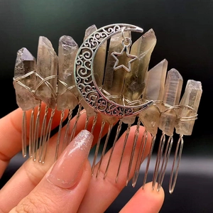 Macro detail of handmade crystal hair comb featuring moon and star charms on metal base