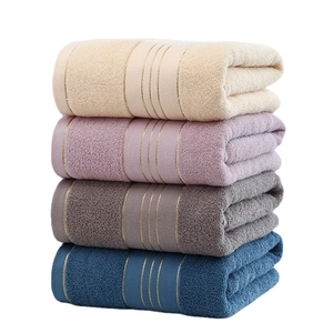Thick soft cotton bath towels set in beige, pink, grey and navy blue stacked on white