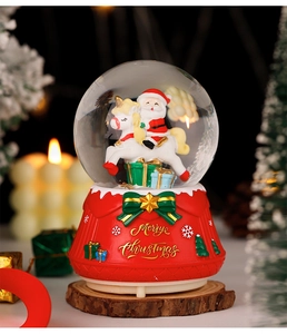Detailed view of red Christmas snow globe with Santa Claus riding a unicorn