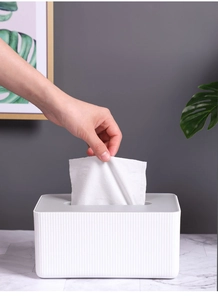 Close-up of hand pulling a tissue from a Nordic grey and white striped tissue box
