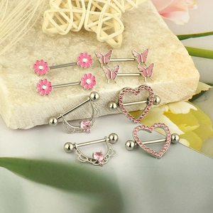 Pink heart and butterfly nipple rings in stainless steel on a textured stone background