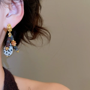 Detailed close-up of ethnic style beaded drop earrings with dalmatian jasper stone