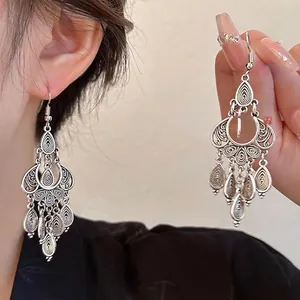 Gros plan détaillé sur des boucles d'oreilles bohèmes en argent avec motifs et pampilles