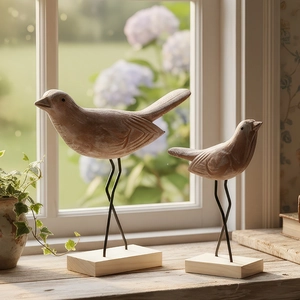Paar Scandinavische houten vogelornamenten met metalen poten op een houten basis