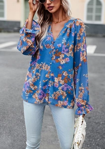 Dettaglio della camicetta blu a fiori con scollo a V, volant e chiusura a bottoni