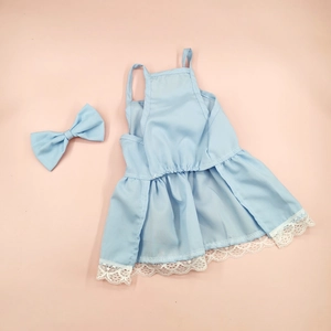 Detail of light blue floral dog dress with lace hem and matching bow accessory