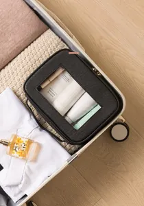 Dettaglio della borsa cosmetica nera con finestra in PVC trasparente e cerniera dorata