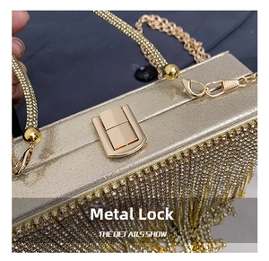 Detail of elegant gold evening clutch showing hardware clasp and tassel fringe