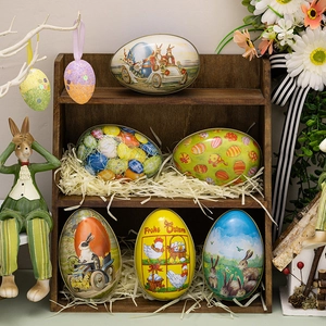 Easter tin egg storage boxes with vintage rabbit designs on a rustic wooden shelf