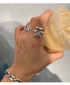 Detail of hand wearing irregular 925 silver ring with square crystal and chunky chain