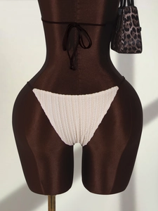Détail du bas de bikini blanc côtelé sur un mannequin avec un sac imprimé léopard