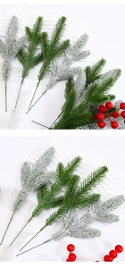 Detail of artificial pine branches with red berries and snow coating for DIY Xmas decor