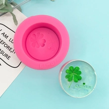 Detail of pink silicone clover mold with round handmade soap showing Good Luck engraving