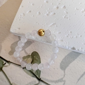 Detailed view of elastic beaded ring with translucent natural stones and a gold accent bead