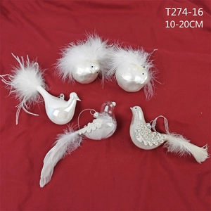 Detailed view of white bird Christmas ornaments with feathers on a red fabric background