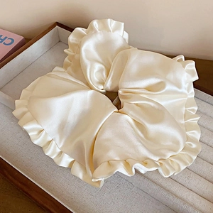 Détail de chouchous en satin crème avec bords volantés élégants et texture soyeuse