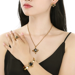 Luxury gold stainless steel jewelry set with black geometric stone on elegant model