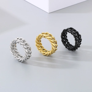 Cuban link chain rings in gold, silver, and black finishes on a grey background