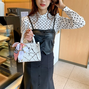 White marble pattern tote bag with pink silk scarf detail shown in a cafe setting