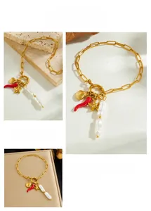 Dettaglio del bracciale dorato con ciondoli a forma di peperoncino, stella e perle