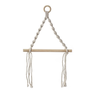 Bohemian macrame paper towel holder with woven cotton rope and natural wood rod