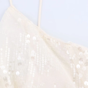 Détail de paillettes blanches délicates et de fines bretelles sur une robe courte
