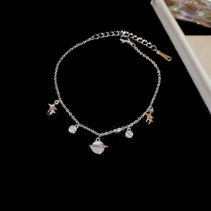 Detailed view of silver charm bracelet with zircon stars and white Saturn pendant charms
