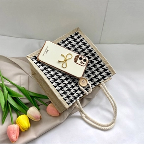 Detail of houndstooth canvas tote bag featuring wooden button and cotton rope handles