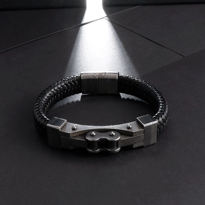 Makroaufnahme eines geflochtenen Lederarmbands mit gealterter Metall-Fahrradkette