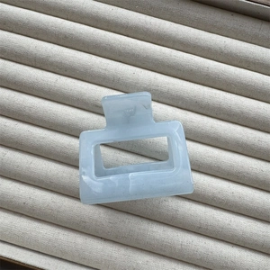 Detail of blue marble ink pattern on square cellulose acetate hair claw clip
