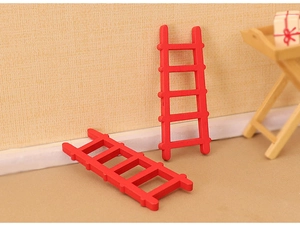 Close-up of two miniature red wooden ladders for dollhouse and Christmas scene decoration