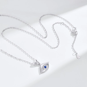 Macro detail of S925 sterling silver evil eye pendant with blue crystal and pavé stones