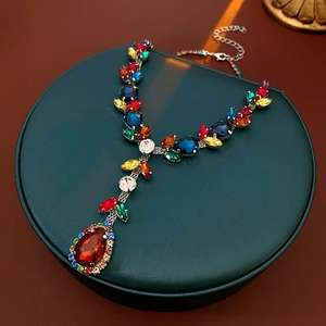 Close-up of vintage necklace with colorful teardrop gemstones and silver chain
