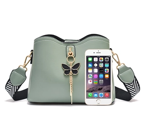 Detail of light green bow shell bag with striped wide strap and phone for size reference