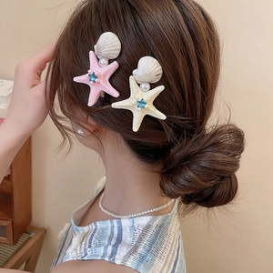 Detail showing starfish and shell hair clips with pearls and rhinestones on hair