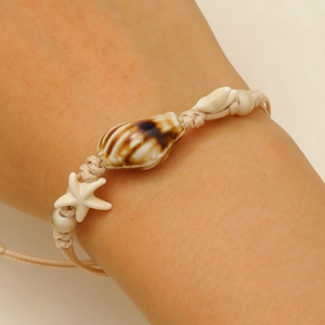 Detail of hand-woven shell starfish bracelet with beige wax rope and natural beads