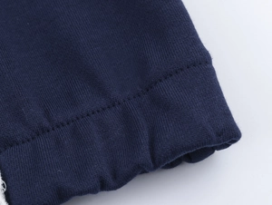 Détail du tricot bleu marine avec double surpiqûre renforcée sur le poignet du sweat