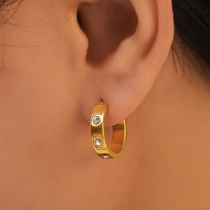 Polished 18K gold plated C-shaped hoop earrings with cubic zirconia on model