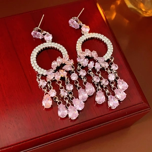 Detail view of pink crystal fringe earrings with silver-tone metal in a luxury red gift box