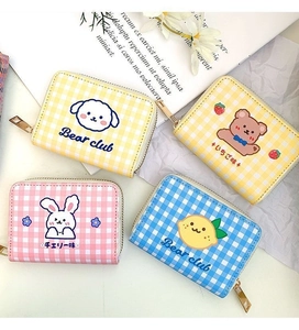 Flat lay of four cartoon zip card holders in yellow, pink, and blue plaid patterns