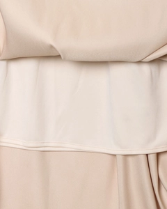 Détail de jupe en satin beige montrant la texture lisse et la couture de l'ourlet