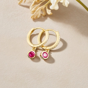 Detail of S925 silver gold hoop earrings with micro-set zircon and magenta gemstone