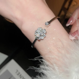 Dettaglio del bracciale aperto in argento con fiore in zirconi scintillanti e petali a strati