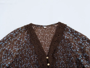 Detailed close-up of V-neckline with brown crochet lace trim on floral chiffon dress