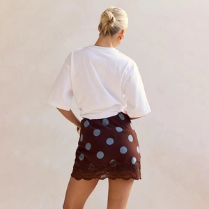 Back view of high waist polka dot mini skirt with lace trim and white T-shirt