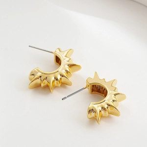 Detail shot of vintage 18K gold C-shaped earrings with unique sunburst spike design