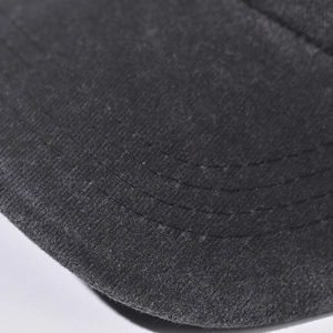 Dettaglio ravvicinato della visiera di un cappellino da baseball in cotone lavato.