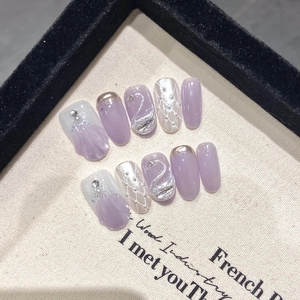 Handmade press-on nails featuring 3D swan carving and lilac cat-eye French style