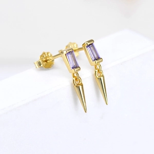 Macro view of S925 silver gold-plated earrings with purple zircon and conical spike pendant